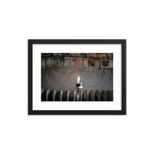 Framed Photo Print Poster "Flame Of Hope". Shows a burning candle with different currency bills in the background. Shot at a cafe is Stockholm. Photography by Jacob Sellström. Printed on matte paper with wooden frame. Two sizes: 8x10, 12x16.